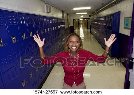 Portrait of a cheerful female teacher standing by locker View Large Photo Image Stock Photo - Portrait of a cheerful female teacher standing by locker. Fotosearch