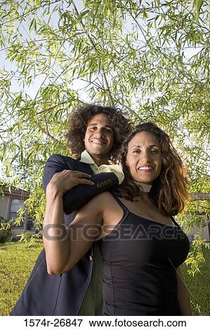 Stock Photo - Portrait of a cheerful man and a mature woman standing in the lawn. Fotosearch