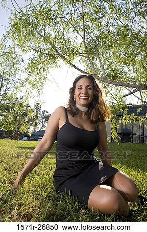 Portrait of a cheerful mature woman sitting in the lawn View Large Photo Image Stock Image - Portrait of a cheerful mature woman sitting in the lawn. Fotosearch