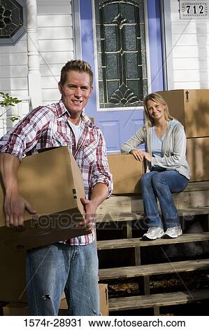 Portrait of a cheerful mid adult couple moving cardboard boxes View Large Photo Image Stock Image - Portrait of a cheerful mid adult couple moving cardboard boxes. Fotosearch
