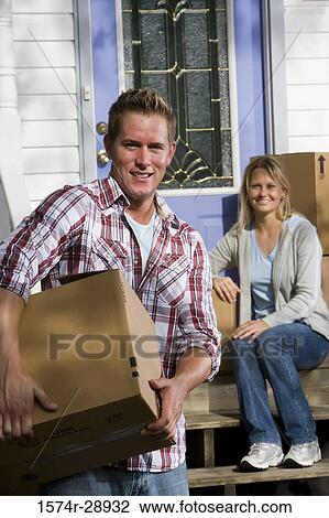 Portrait of a cheerful mid adult couple moving cardboard boxes View Large Photo Image Stock Image - Portrait of a cheerful mid adult couple moving cardboard boxes. Fotosearch