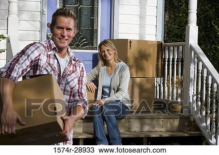 Portrait of a cheerful mid adult couple moving cardboard boxes View Large Photo Image Stock Image - Portrait of a cheerful mid adult couple moving cardboard boxes. Fotosearch