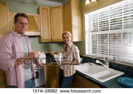 Portrait of a cheerful mid adult couple eating fast food in the kitchen View Large Photo Image Stock Image - Portrait of a cheerful mid adult couple eating fast food in the kitchen. Fotosearch