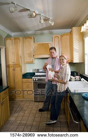 Portrait of a cheerful mid adult couple eating in the kitchen View Large Photo Image Stock Photo - Portrait of a cheerful mid adult couple eating in the kitchen. Fotosearch