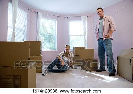 Portrait of a cheerful mid adult couple by cardboard boxes in a house View Large Photo Image Stock Photograph - Portrait of a cheerful mid adult couple by cardboard boxes in a house. Fotosearch
