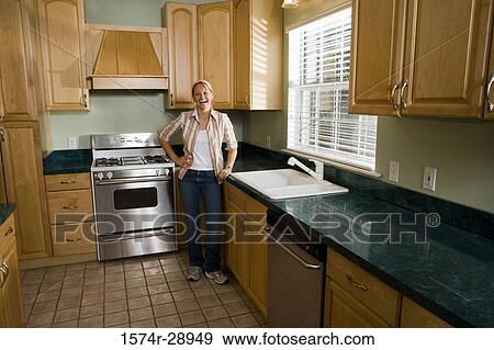 Portrait of a cheerful mid adult woman standing kitchen counter in the kitchen View Large Photo Image Stock Photo - Portrait of a cheerful mid adult woman standing kitchen counter in the kitchen. Fotosearch
