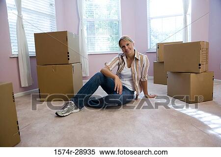 Portrait of a cheerful mid adult woman sitting by cardboard boxes View Large Photo Image Stock Photography - Portrait of a cheerful mid adult woman sitting by cardboard boxes. Fotosearch