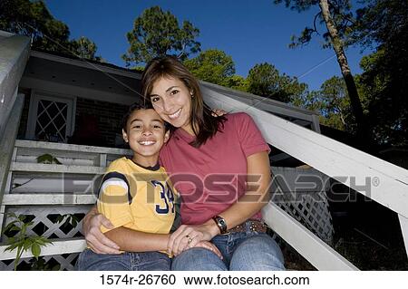 Portrait of a cheerful mother embracing her son on the staircase View Large Photo Image Stock Image - Portrait of a cheerful mother embracing her son on the staircase. Fotosearch