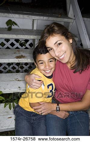 Portrait of a cheerful mother embracing her son on the staircase View Large Photo Image Stock Photo - Portrait of a cheerful mother embracing her son on the staircase. Fotosearch