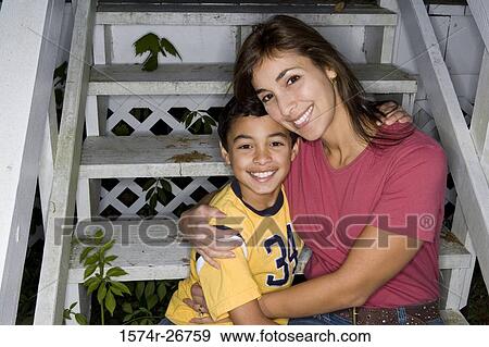 Portrait of a cheerful mother embracing her son on the staircase View Large Photo Image Stock Photo - Portrait of a cheerful mother embracing her son on the staircase. Fotosearch