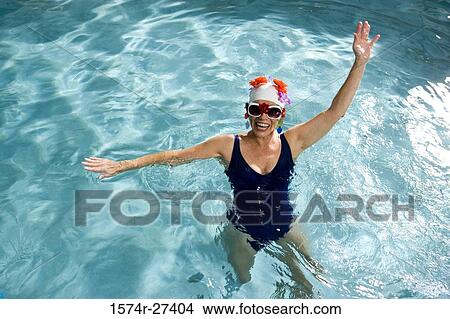 Portrait of a cheerful senior woman swimming in swimming pool View Large Photo Image Picture - Portrait of a cheerful senior woman swimming in swimming pool. Fotosearch