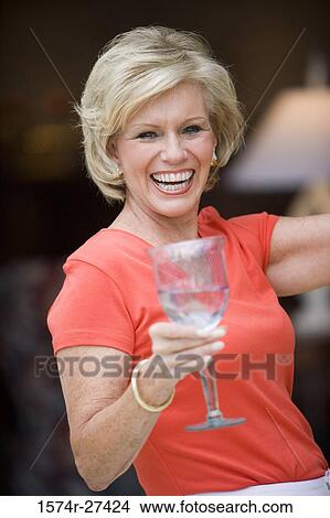 Picture - Portrait of a cheerful senior woman holding wineglass. Fotosearch