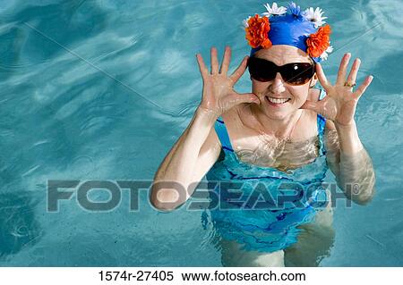 Portrait of a cheerful senior woman swimming in swimming pool View Large Photo Image Stock Photography - Portrait of a cheerful senior woman swimming in swimming pool. Fotosearch