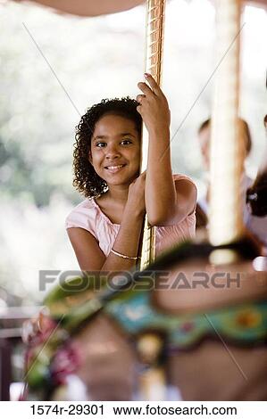 Portrait of a cheerful teenage girl sitting on a carousel View Large Photo Image Stock Image - Portrait of a cheerful teenage girl sitting on a carousel. Fotosearch