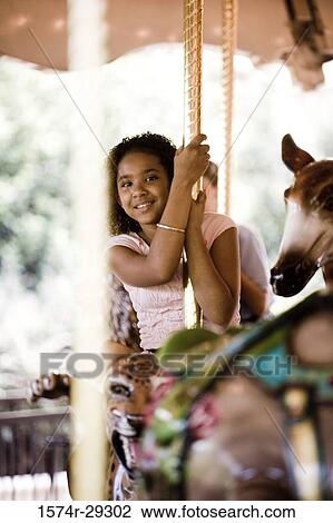 Portrait of a cheerful teenage girl sitting on a carousel View Large Photo Image Stock Image - Portrait of a cheerful teenage girl sitting on a carousel. Fotosearch
