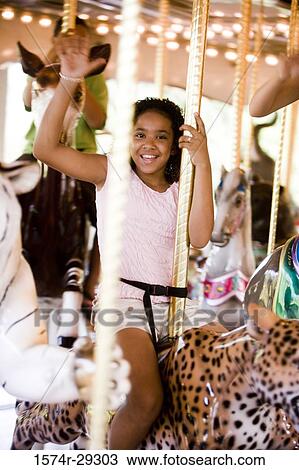 Portrait of a cheerful teenage girl sitting on a carousel and waving hand View Large Photo Image Stock Image - Portrait of a cheerful teenage girl sitting on a carousel and waving hand. Fotosearch