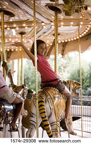 Portrait of a cheerful teenage girls sitting on a carousel and waving hands View Large Photo Image Stock Photo - Portrait of a cheerful teenage girls sitting on a carousel and waving hands. Fotosearch