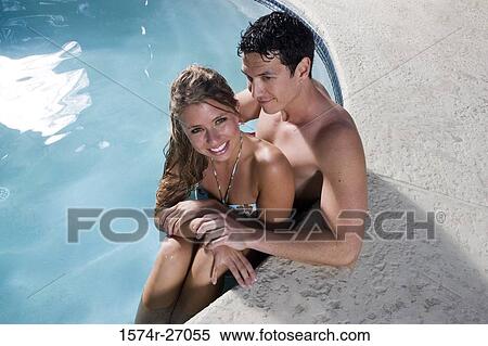 Portrait of a cheerful young couple sitting in swimming pool View Large Photo Image Stock Photography - Portrait of a cheerful young couple sitting in swimming pool. Fotosearch