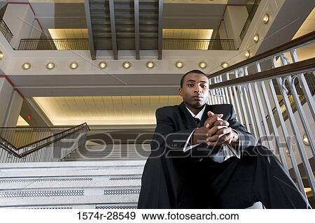 Portrait of a contemplative businessman standing on staircase in an office View Large Photo Image Stock Photo - Portrait of a contemplative businessman standing on staircase in an office. Fotosearch