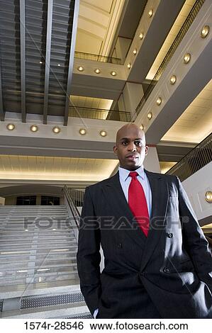 Portrait of a contemplative businessman standing on staircase in an office View Large Photo Image Stock Photograph - Portrait of a contemplative businessman standing on staircase in an office. Fotosearch