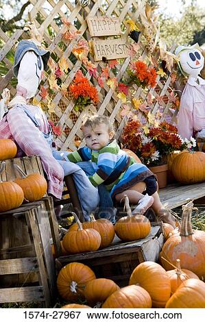 Portrait of a cute boy in warm clothing standing by scarecrow View Large Photo Image Stock Photo - Portrait of a cute boy in warm clothing standing by scarecrow. Fotosearch