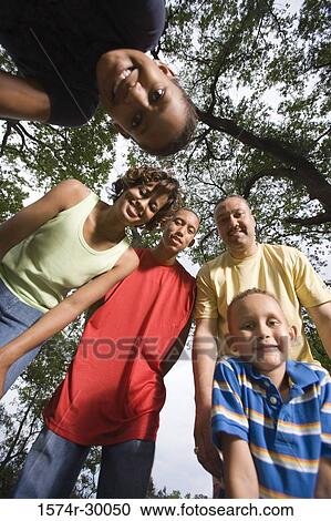 Stock Image - Portrait of a family standing at park. Fotosearch