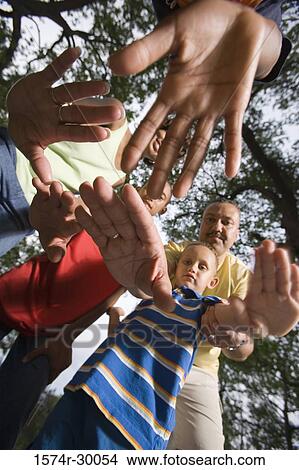 Portrait of a family standing with arms raised at park View Large Photo Image Picture - Portrait of a family standing with arms raised at park. Fotosearch