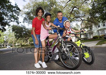 Portrait of a family standing with bicycle on the road View Large Photo Image Stock Image - Portrait of a family standing with bicycle on the road. Fotosearch