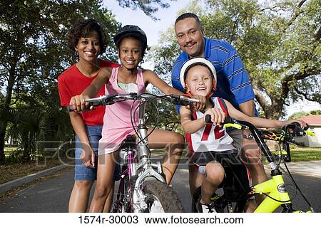 Portrait of a family standing with bicycle on the road View Large Photo Image Stock Image - Portrait of a family standing with bicycle on the road. Fotosearch