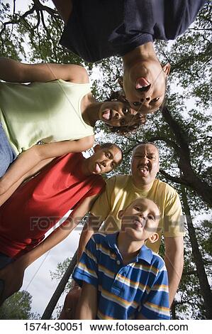 Portrait of a family sticking out tongue and making a face at park View Large Photo Image Stock Image - Portrait of a family sticking out tongue and making a face at park. Fotosearch