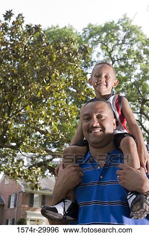 Portrait of a father carrying son on his shoulder View Large Photo Image Stock Photograph - Portrait of a father carrying son on his shoulder. Fotosearch