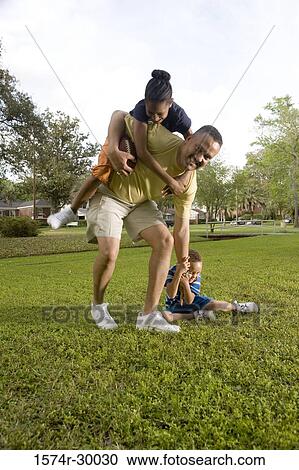 Portrait of a father playing with their children at park View Large Photo Image Stock Image - Portrait of a father playing with their children at park. Fotosearch