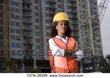 Stock Photo - Portrait of a female architect standing in front of a building under construction. Fotosearch