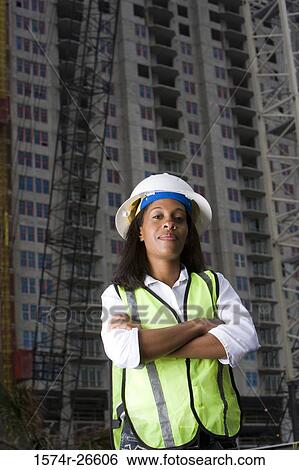Portrait of a female architect standing in front of a building under construction View Large Photo Image Stock Photograph - Portrait of a female architect standing in front of a building under construction. Fotosearch