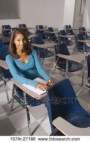 Stock Photograph - Portrait of a female student sitting on a chair in the classroom. Fotosearch