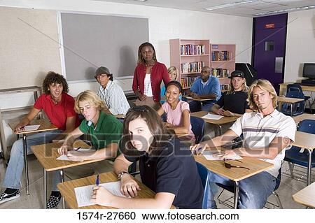 Portrait of a female teacher supervising during exam in the classroom View Large Photo Image Stock Image - Portrait of a female teacher supervising during exam in the classroom. Fotosearch