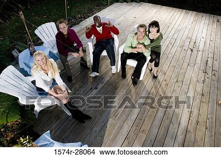 Picture - Portrait of a friends sitting on armchairs on wooden deck. Fotosearch