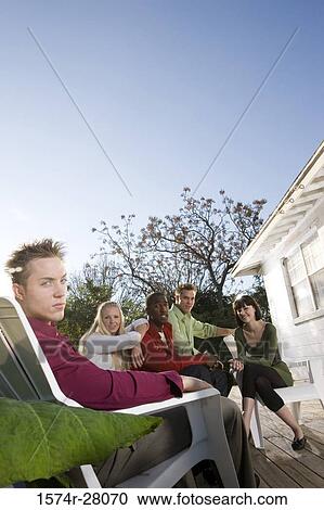 Portrait of a friends sitting on armchairs on wooden deck View Large Photo Image Stock Image - Portrait of a friends sitting on armchairs on wooden deck. Fotosearch