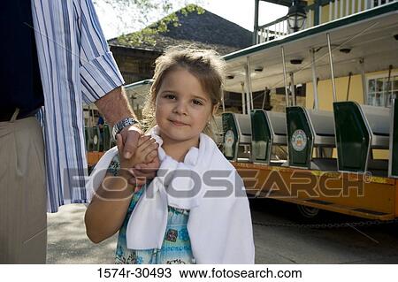Stock Image - Portrait of a girl holding her father's hand. Fotosearch