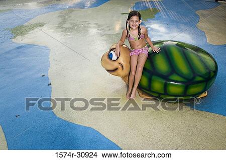 Portrait of a girl sitting on a tortoise sculpture View Large Photo Image Picture - Portrait of a girl sitting on a tortoise sculpture. Fotosearch