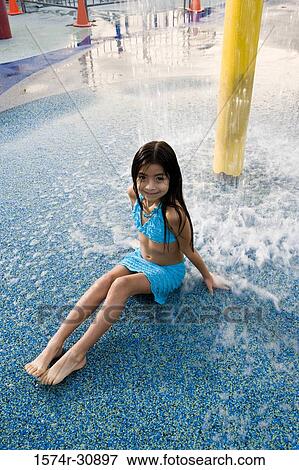 Stock Photo - Portrait of a girl sitting under a shower. Fotosearch