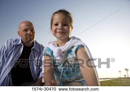 Portrait of a girl sitting with her father View Large Photo Image Stock Image - Portrait of a girl sitting with her father. Fotosearch