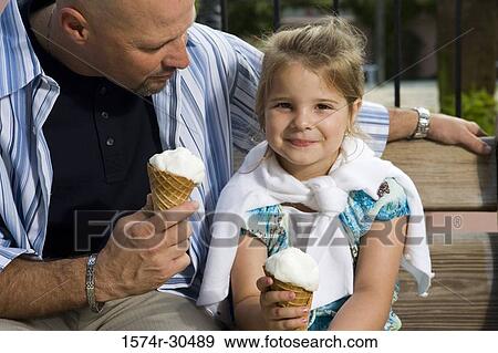 Stock Photo - Portrait of a girl with her father holding ice cream cones. Fotosearch