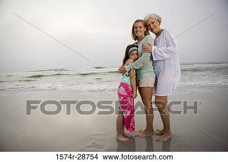 Portrait of a grandmother standing with her daughter and granddaughter at the beach View Large Photo Image Picture - Portrait of a grandmother standing with her daughter and granddaughter at the beach. Fotosearch