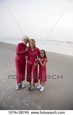 Stock Photography - Portrait of a grandmother standing with her daughter and granddaughter at the beach. Fotosearch