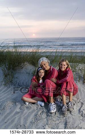 Portrait of a grandmother with her daughter and granddaughter sitting at the beach View Large Photo Image Stock Image - Portrait of a grandmother with her daughter and granddaughter sitting at the beach. Fotosearch