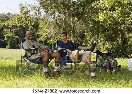 Portrait of a man sitting with his friend and son on chair at forest View Large Photo Image Stock Image - Portrait of a man sitting with his friend and son on chair at forest. Fotosearch