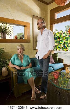 Portrait of a man standing by woman sitting on a sofa View Large Photo Image Stock Photography - Portrait of a man standing by woman sitting on a sofa. Fotosearch