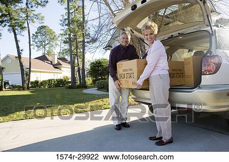Portrait of a mature couple removing a cardboard box from a car View Large Photo Image Stock Image - Portrait of a mature couple removing a cardboard box from a car. Fotosearch