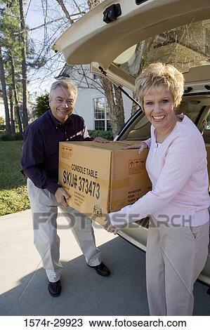 Portrait of a mature couple removing a cardboard box from a car View Large Photo Image Stock Image - Portrait of a mature couple removing a cardboard box from a car. Fotosearch